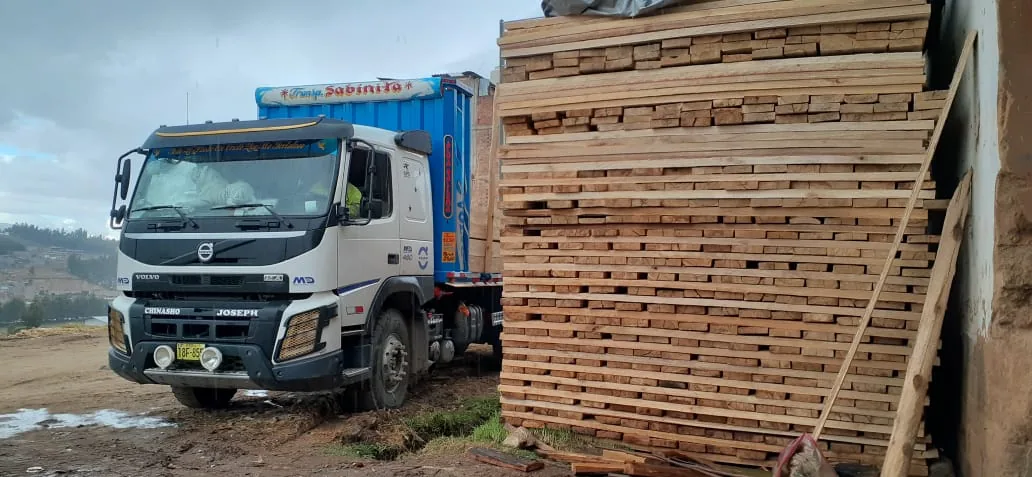 Camión de Sabinita junto a tablas de madera apiladas listas para despacho